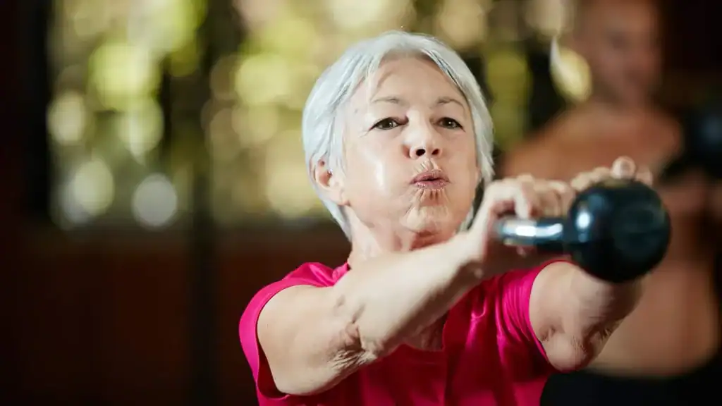 Toning Arms After 60: Empowering Womens Fitness Through Effective Weight Training 1 Older woman doing weight training Wollaton to help her strength and longevity
