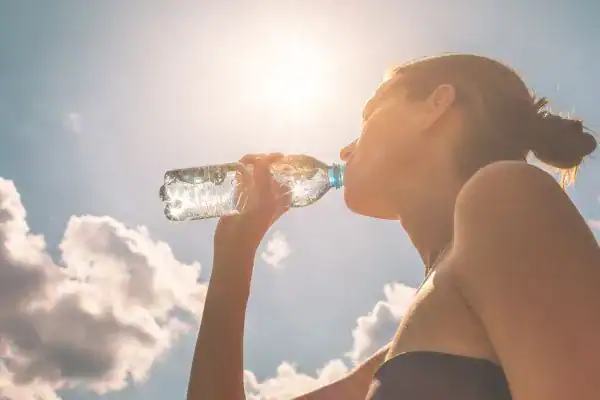 Hydration: The Secret Ingredient for a Toned Stomach and Enhanced Fitness 3 Image of woman drinking water to hydrate Wollaton after run.